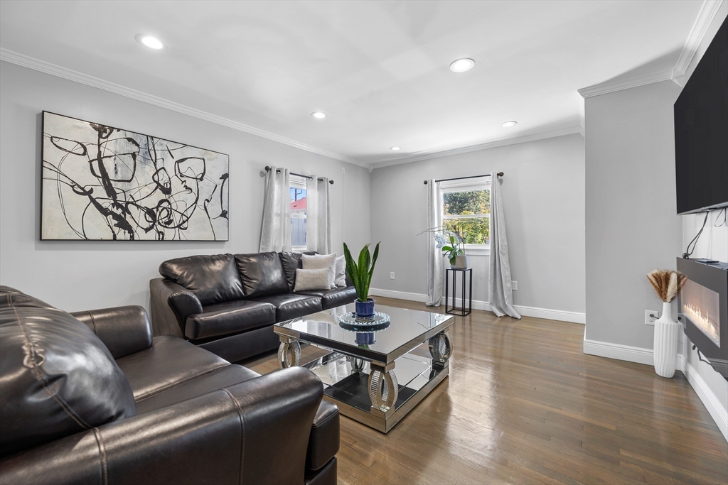 a living room with furniture a flat screen tv and a window