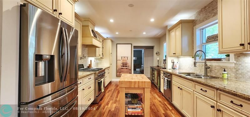 a kitchen with stainless steel appliances granite countertop a refrigerator and a sink