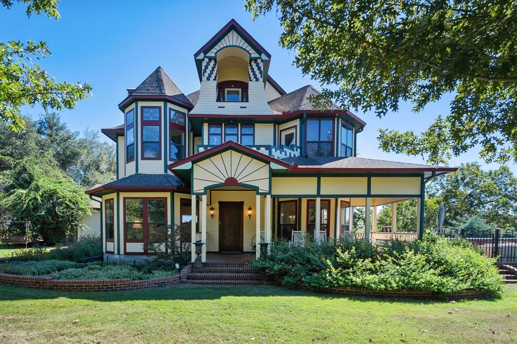 Victorian-style house featuring a front yard and a porch