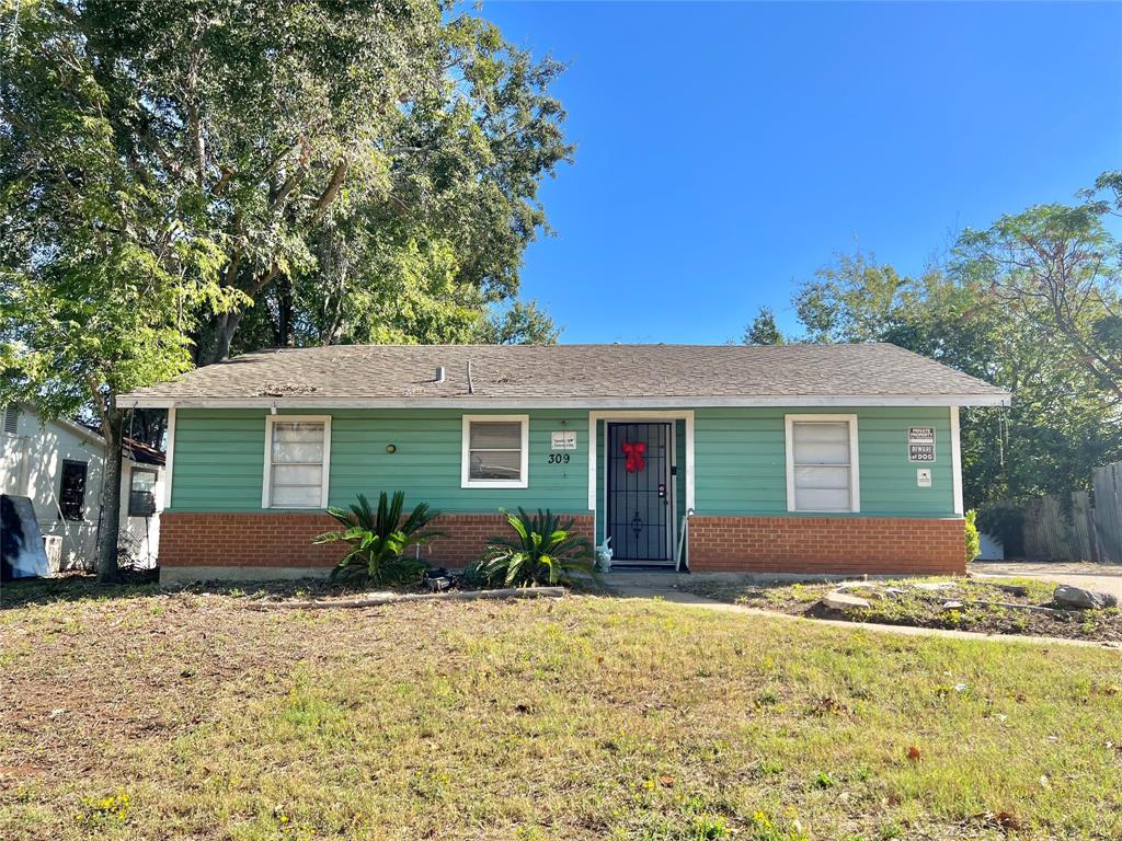 a front view of house with yard and trees around