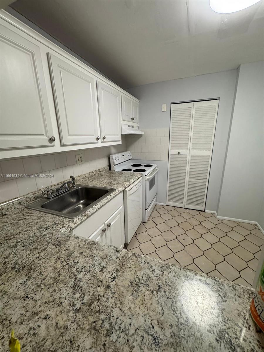 a kitchen with a sink a stove and cabinets