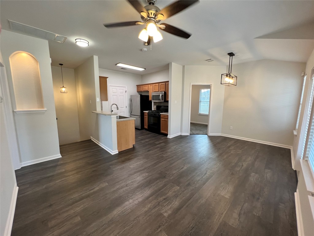 a view of a big room with wooden floor and a kitchen