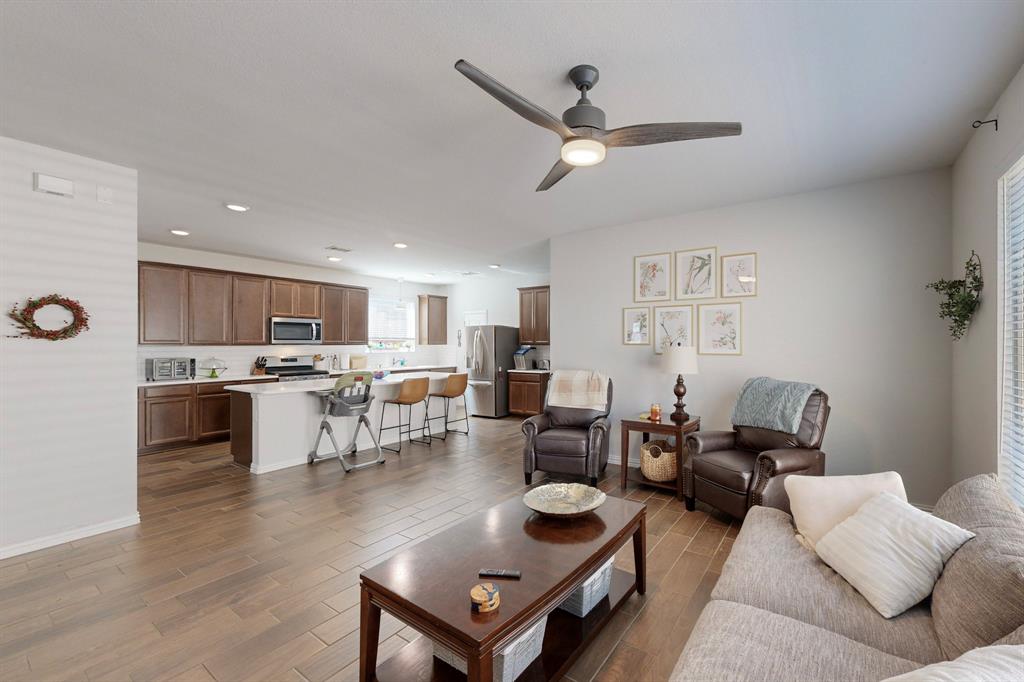 a living room with furniture kitchen view and a window