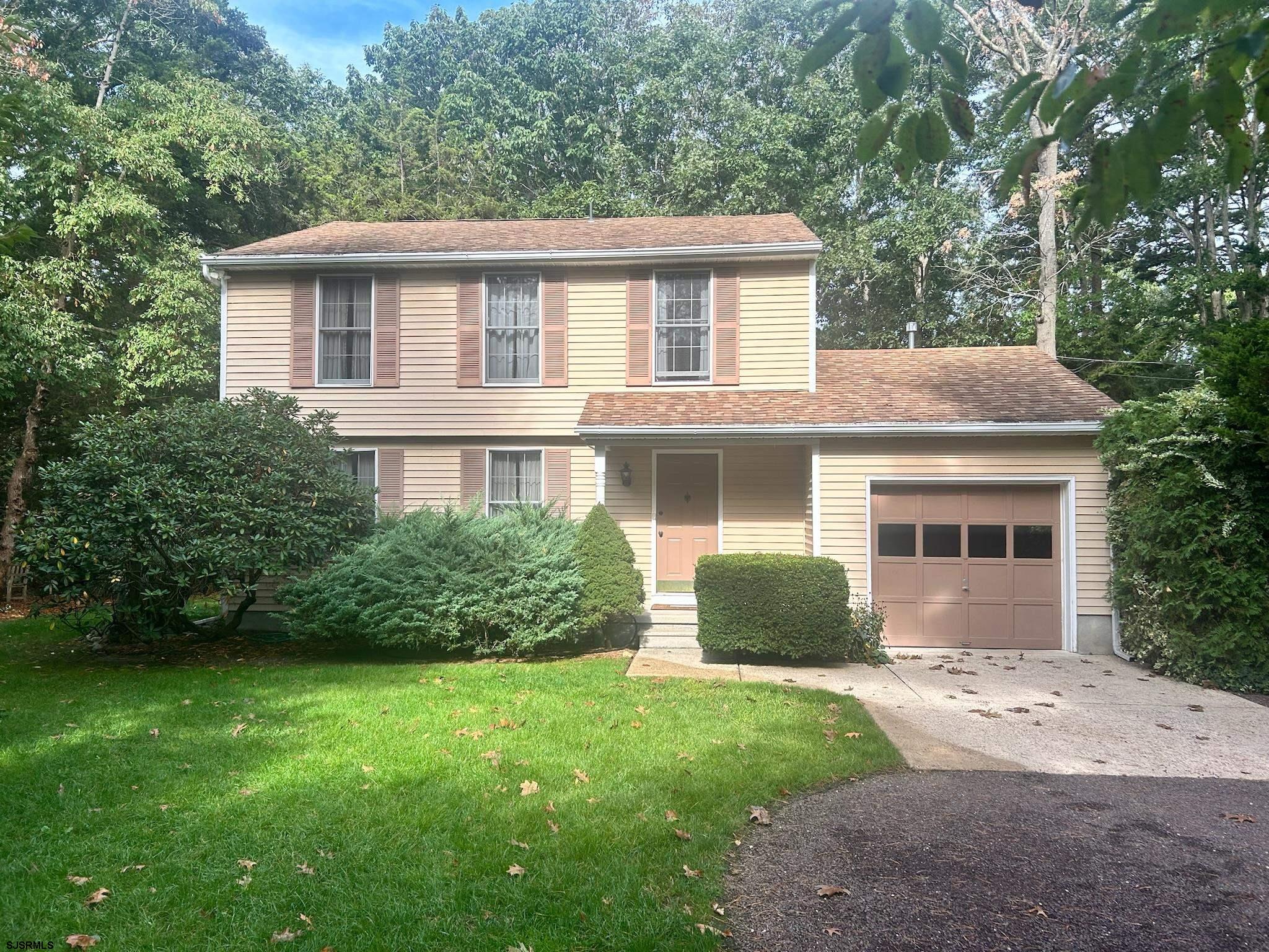 a front view of a house with a garden and yard