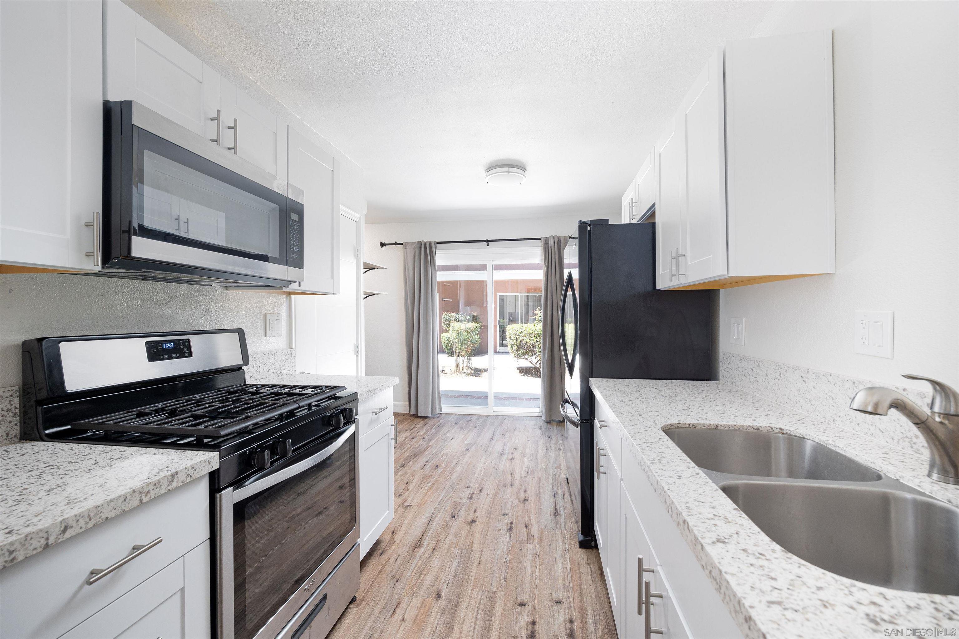 a kitchen with granite countertop a sink and a stove top oven