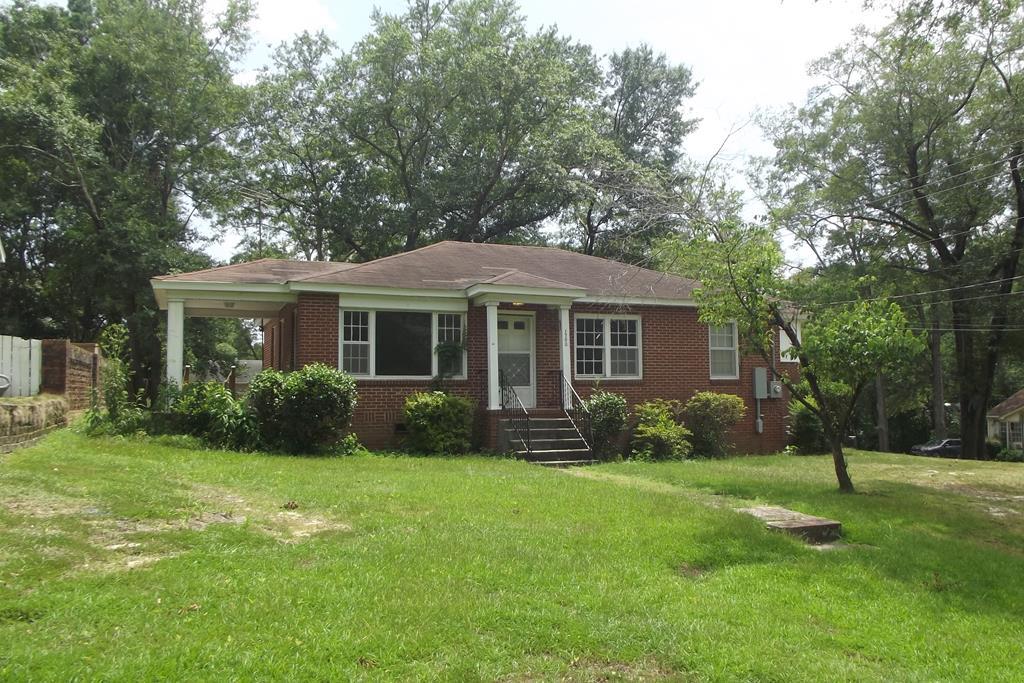 a front view of a house with a yard and trees