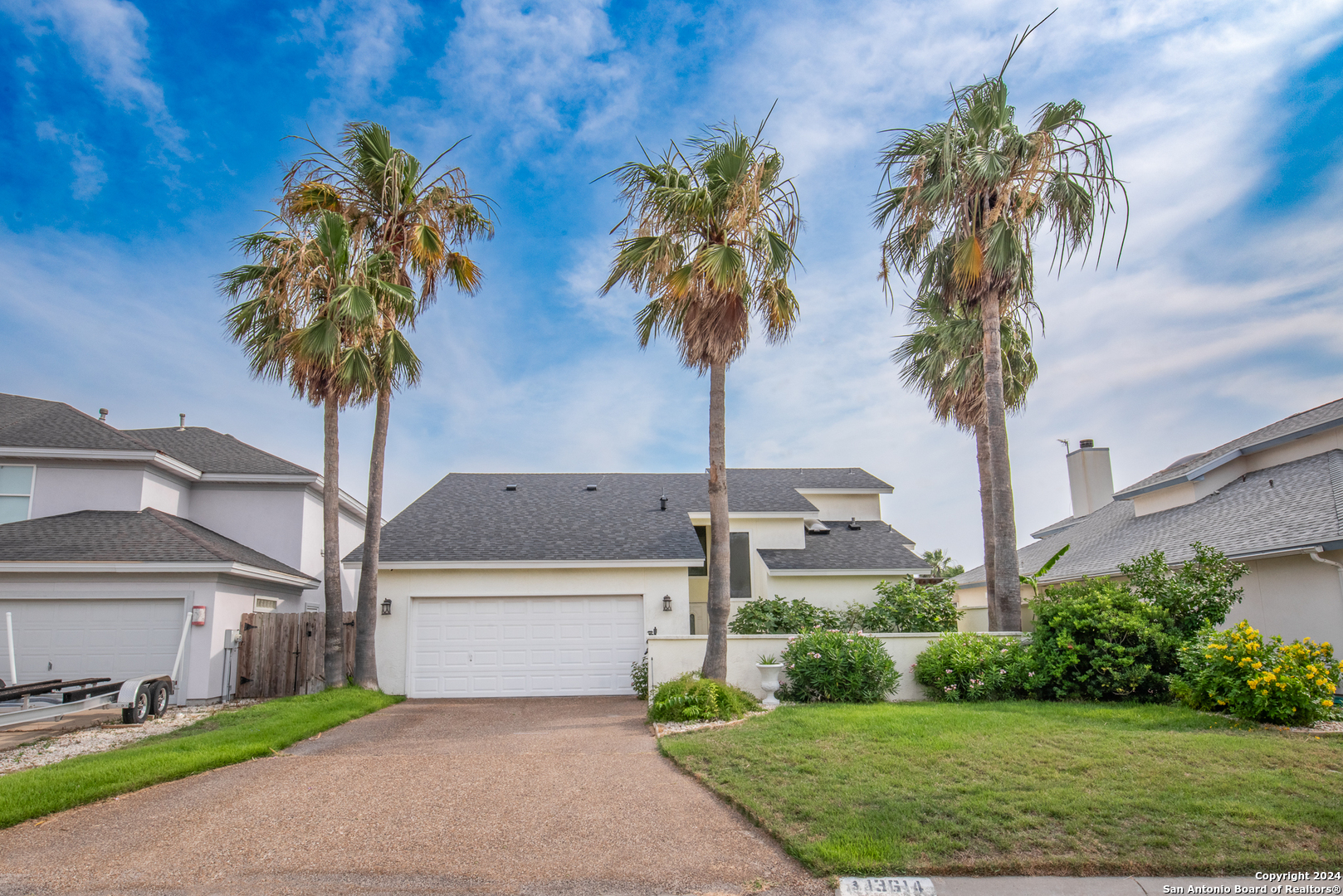 a front view of a house with yard and trees