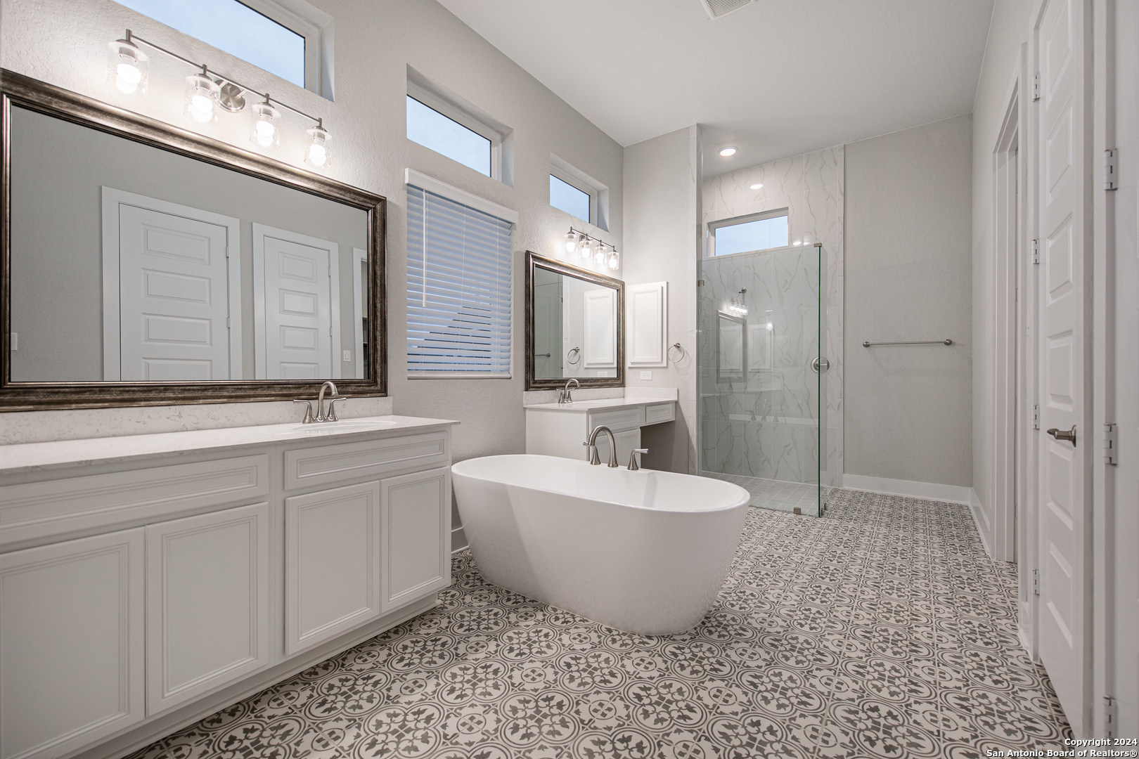 a spacious bathroom with a double vanity sink a mirror and a bathtub