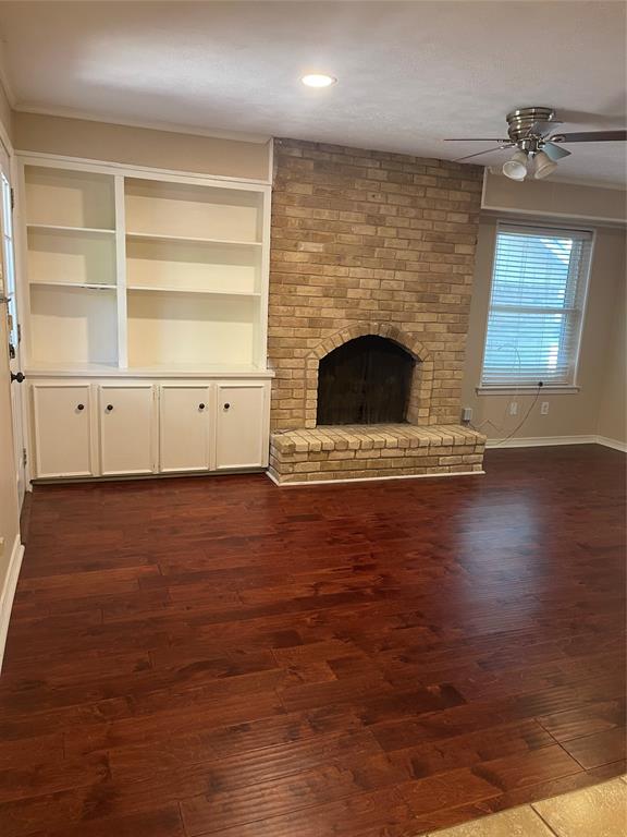 a view of an empty room with a fireplace and a window