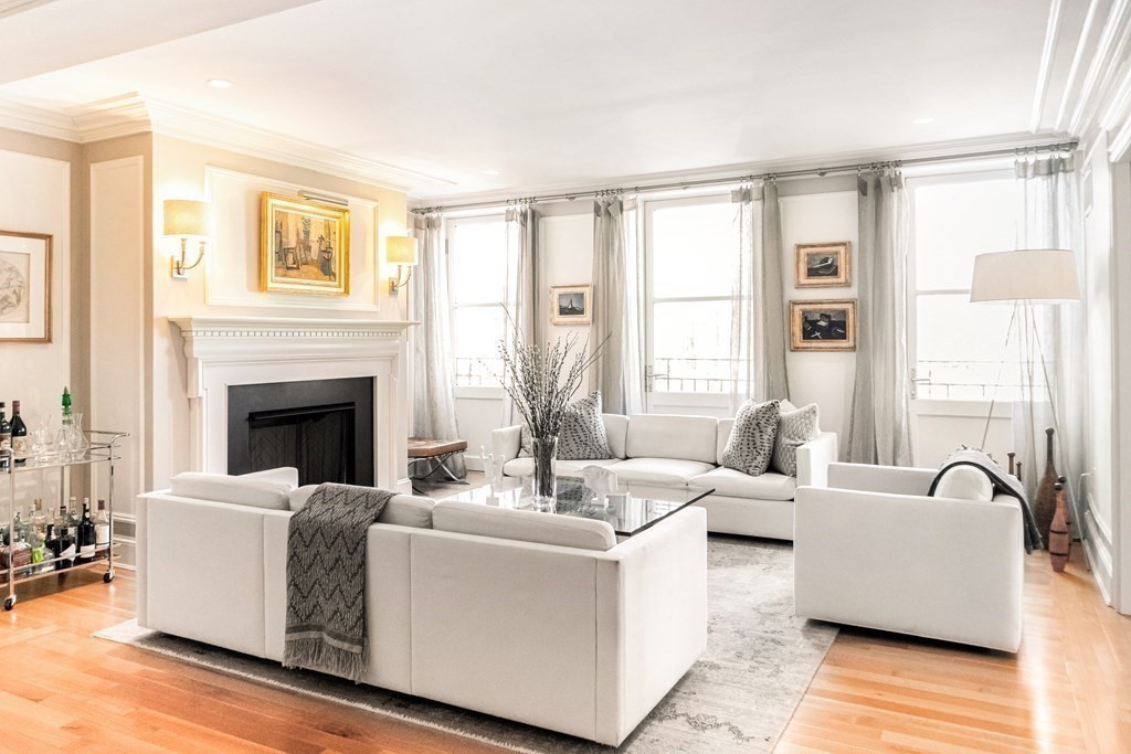 a living room with fireplace furniture and a large window