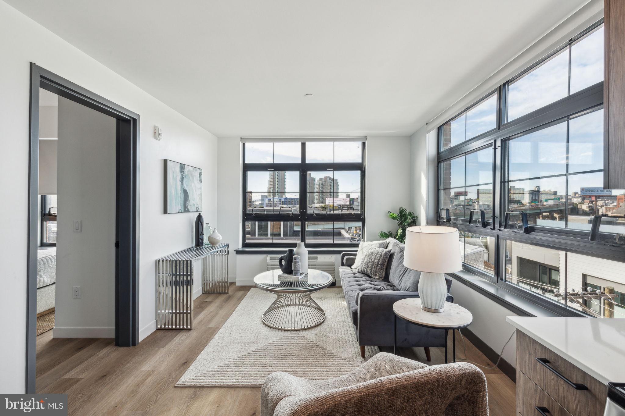 a living room with furniture and a floor to ceiling window