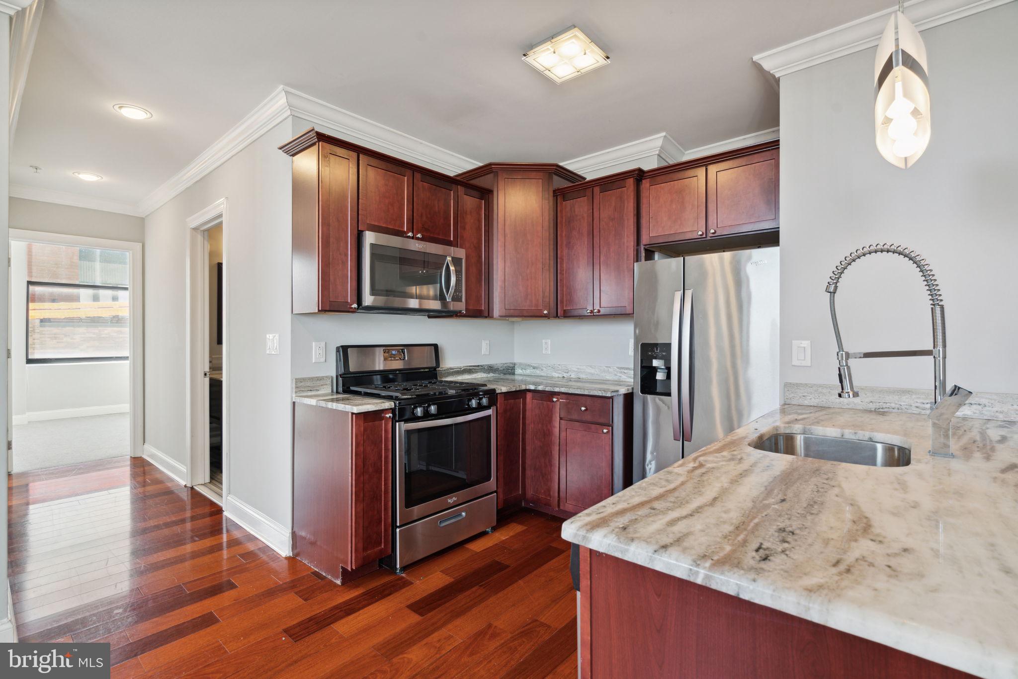 a kitchen with stainless steel appliances granite countertop a stove top oven a sink and dishwasher