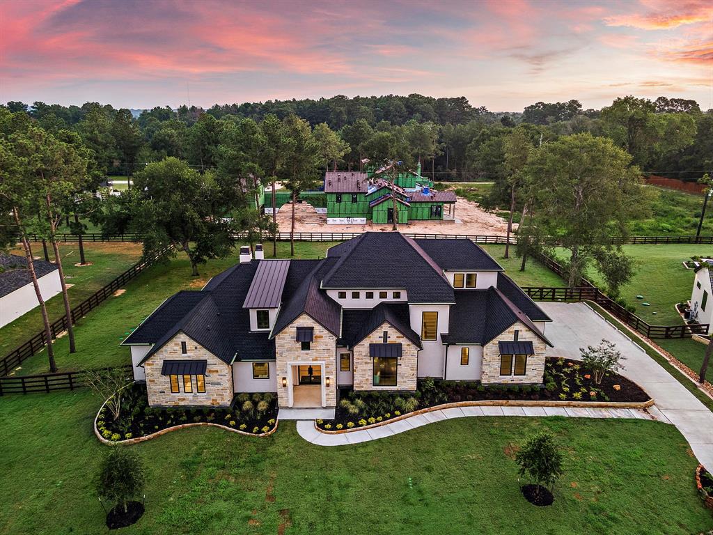 Aerial shot of the beautiful front elevation, showing the fully-fenced, wooded, one-acre lot.