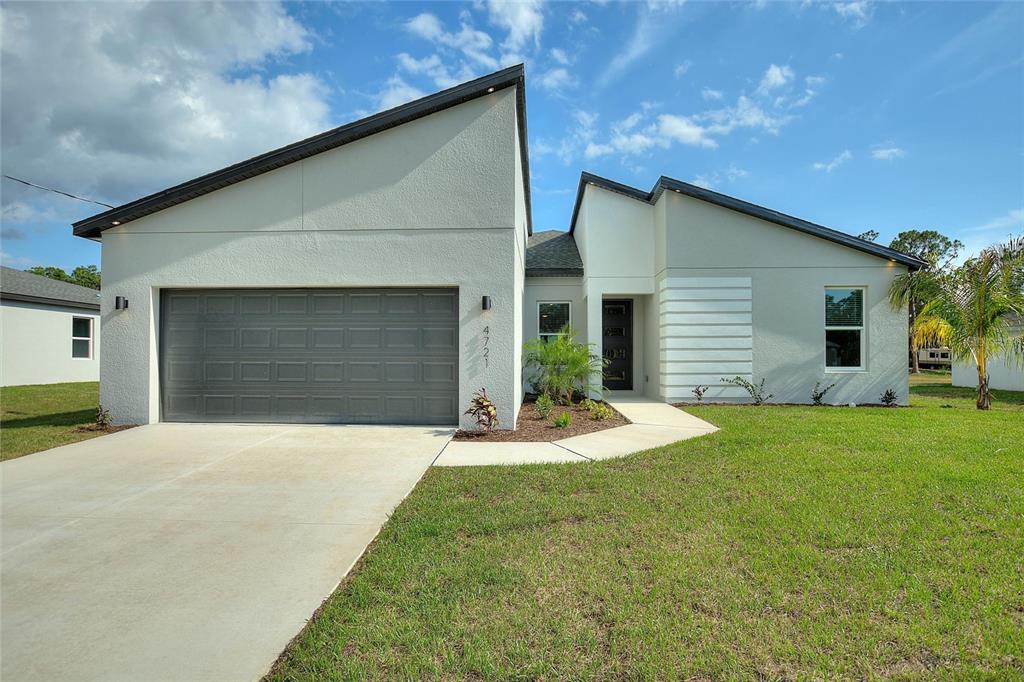 a front view of house with yard and garage