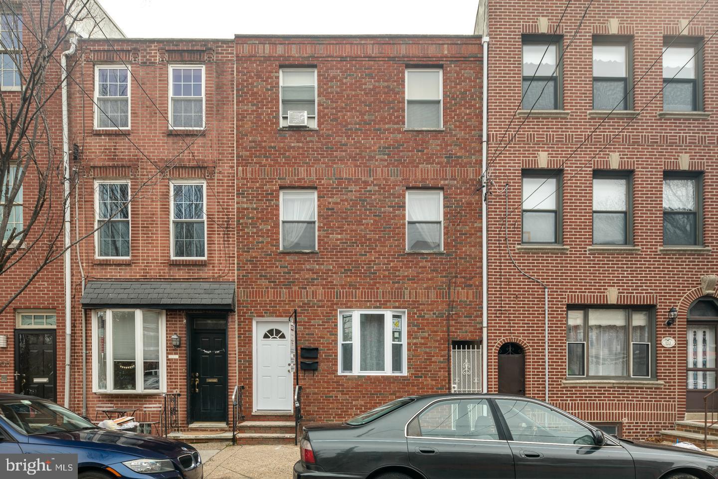 a front view of a building with car parked