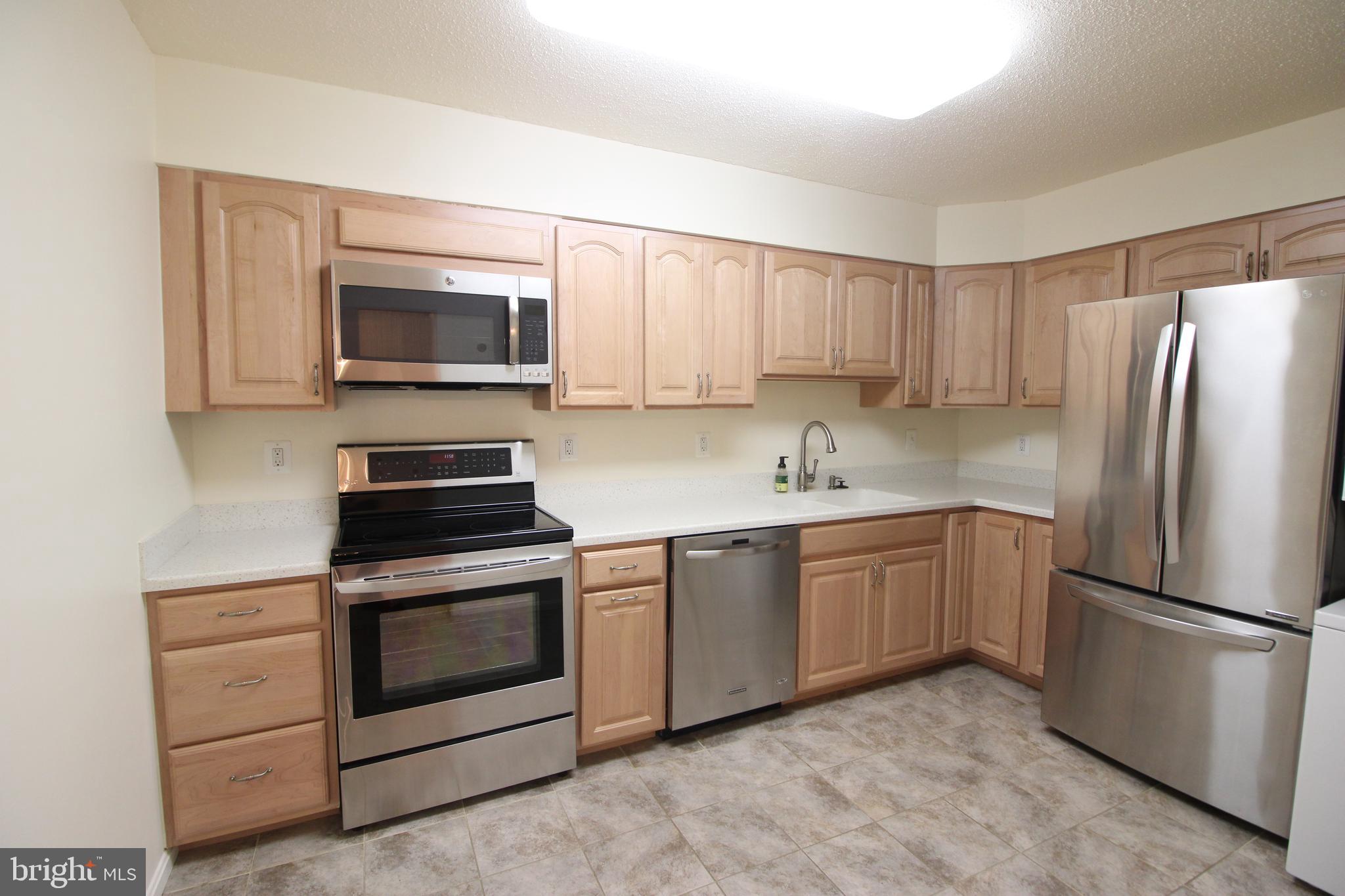 a kitchen with granite countertop stainless steel appliances and white cabinets