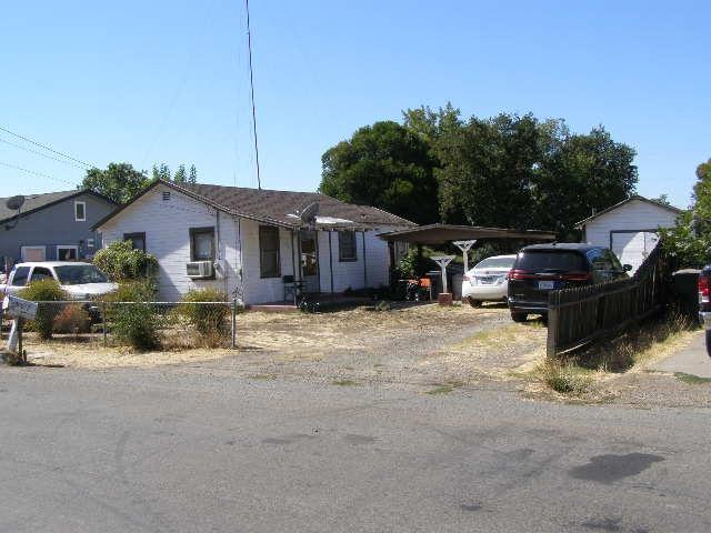 a front view of a house with cars parked