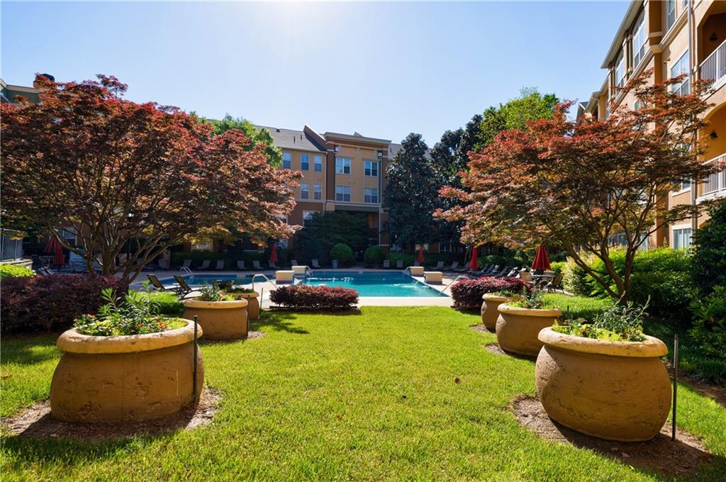 a view of a swimming pool with couches and tables under an umbrella