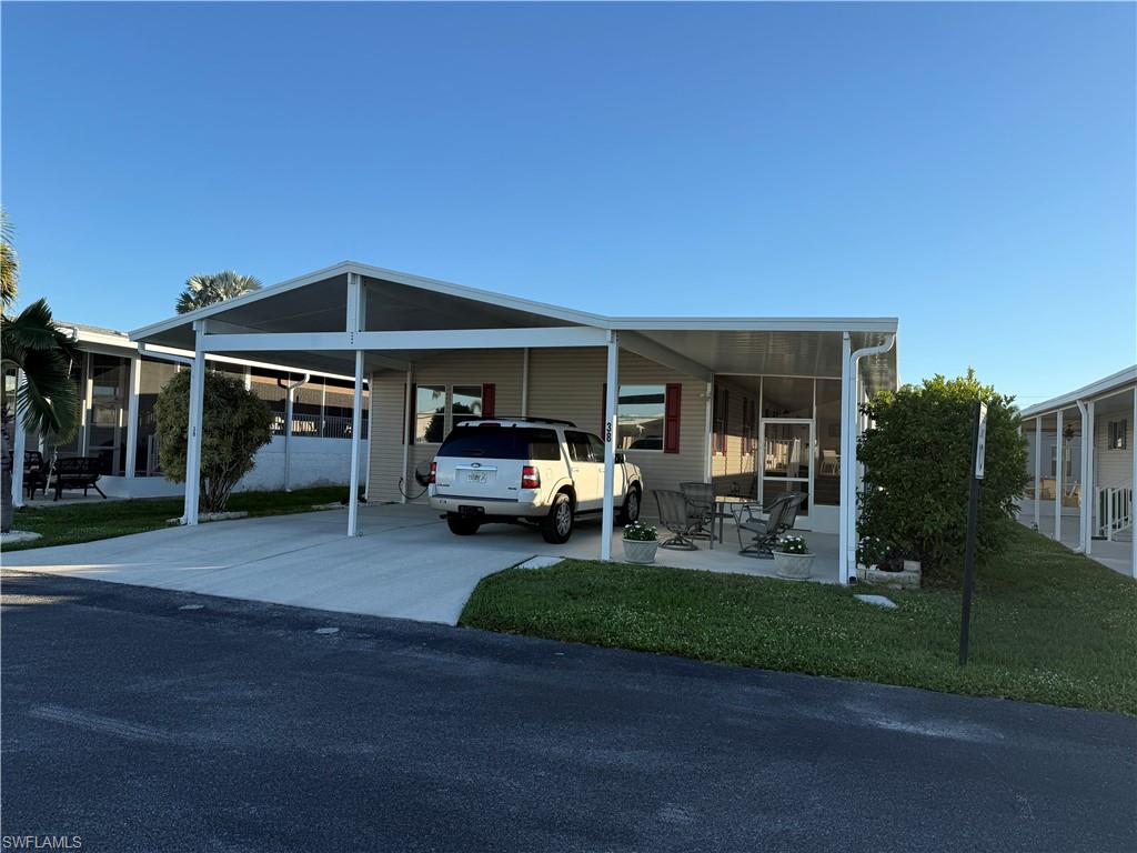 View of front facade with a carport and a front yard