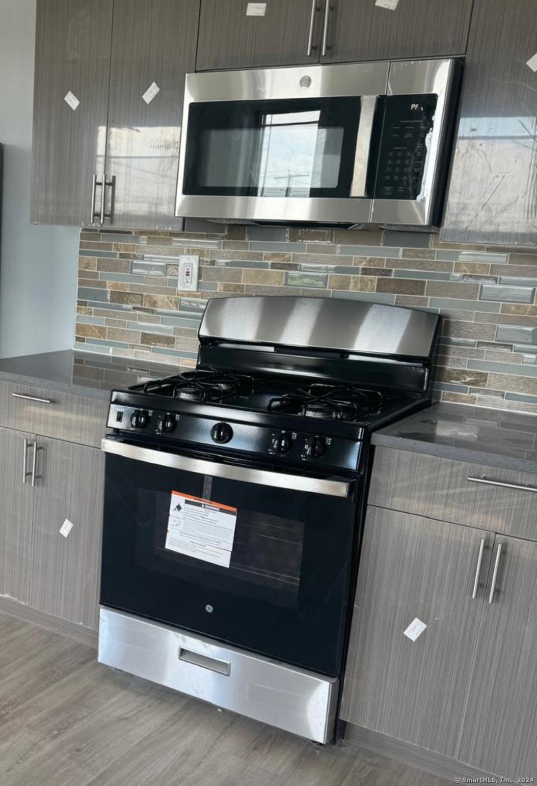 a stove top oven sitting inside of a kitchen