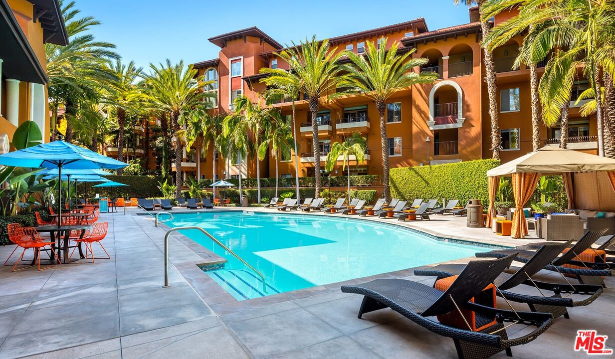 a view of a swimming pool with a table and chairs under an umbrella