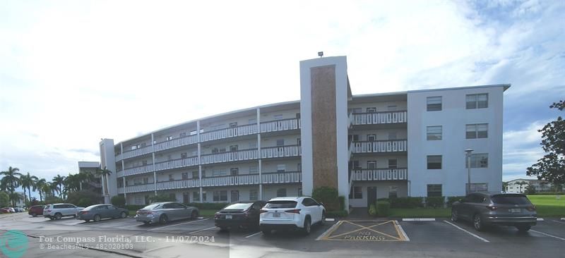 a front view of a building with parking space and a street