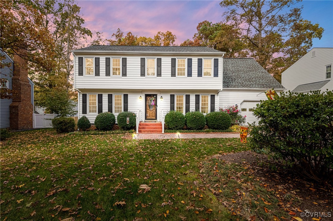 Colonial inspired home featuring a yard