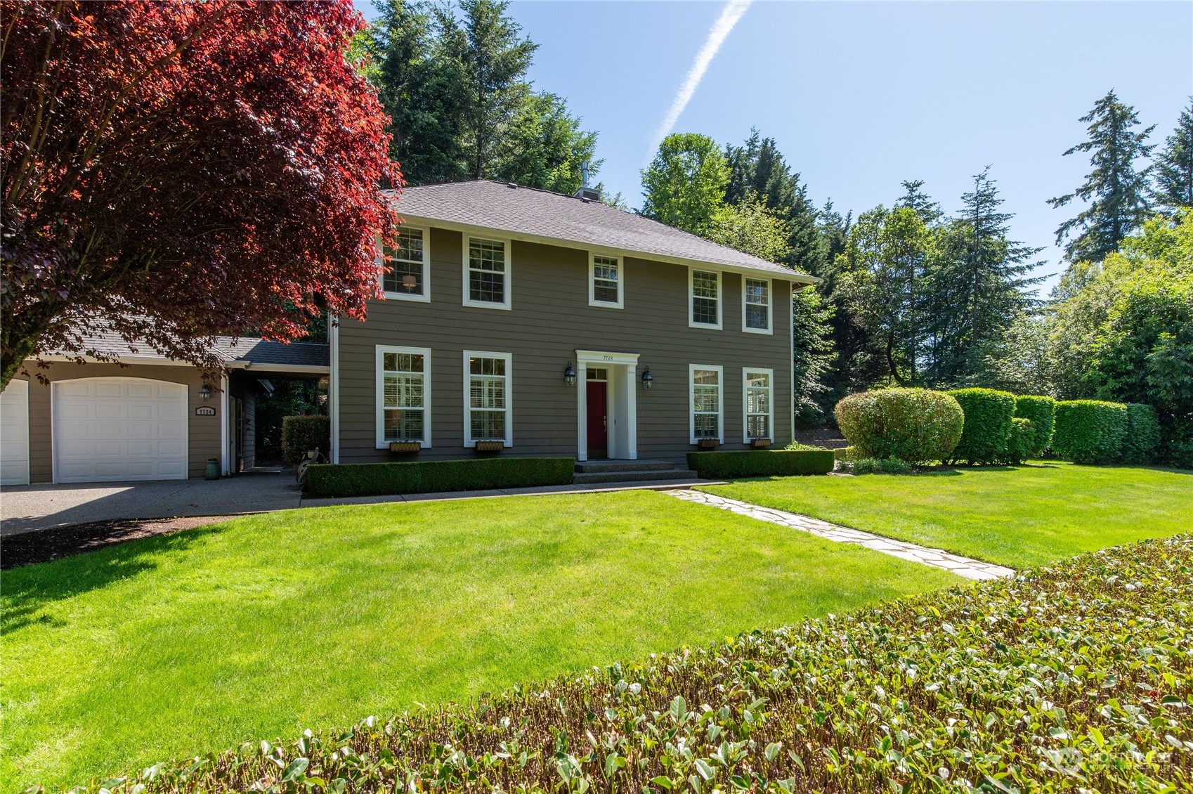 a front view of a house with a garden and yard