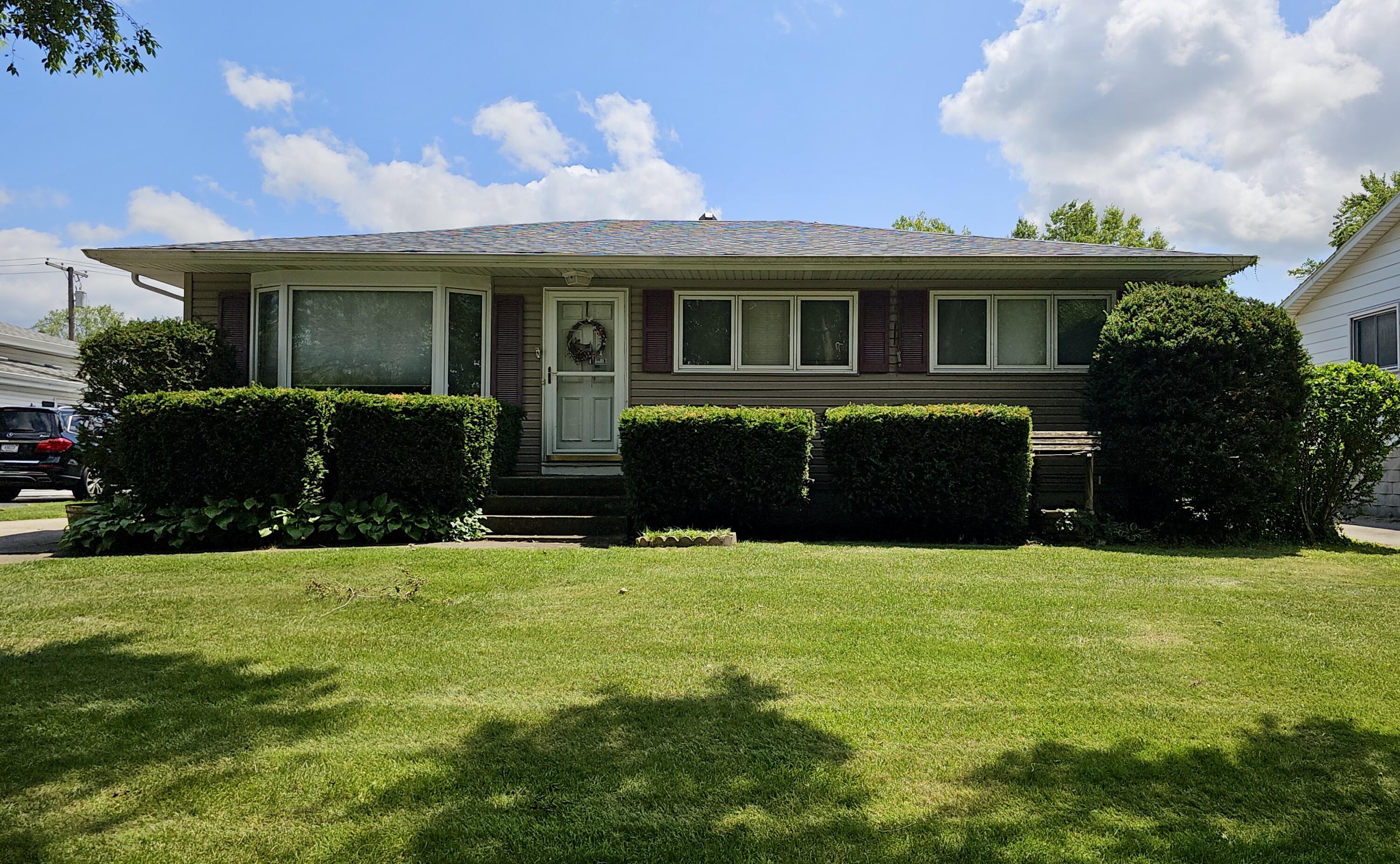 a front view of house with yard and green space