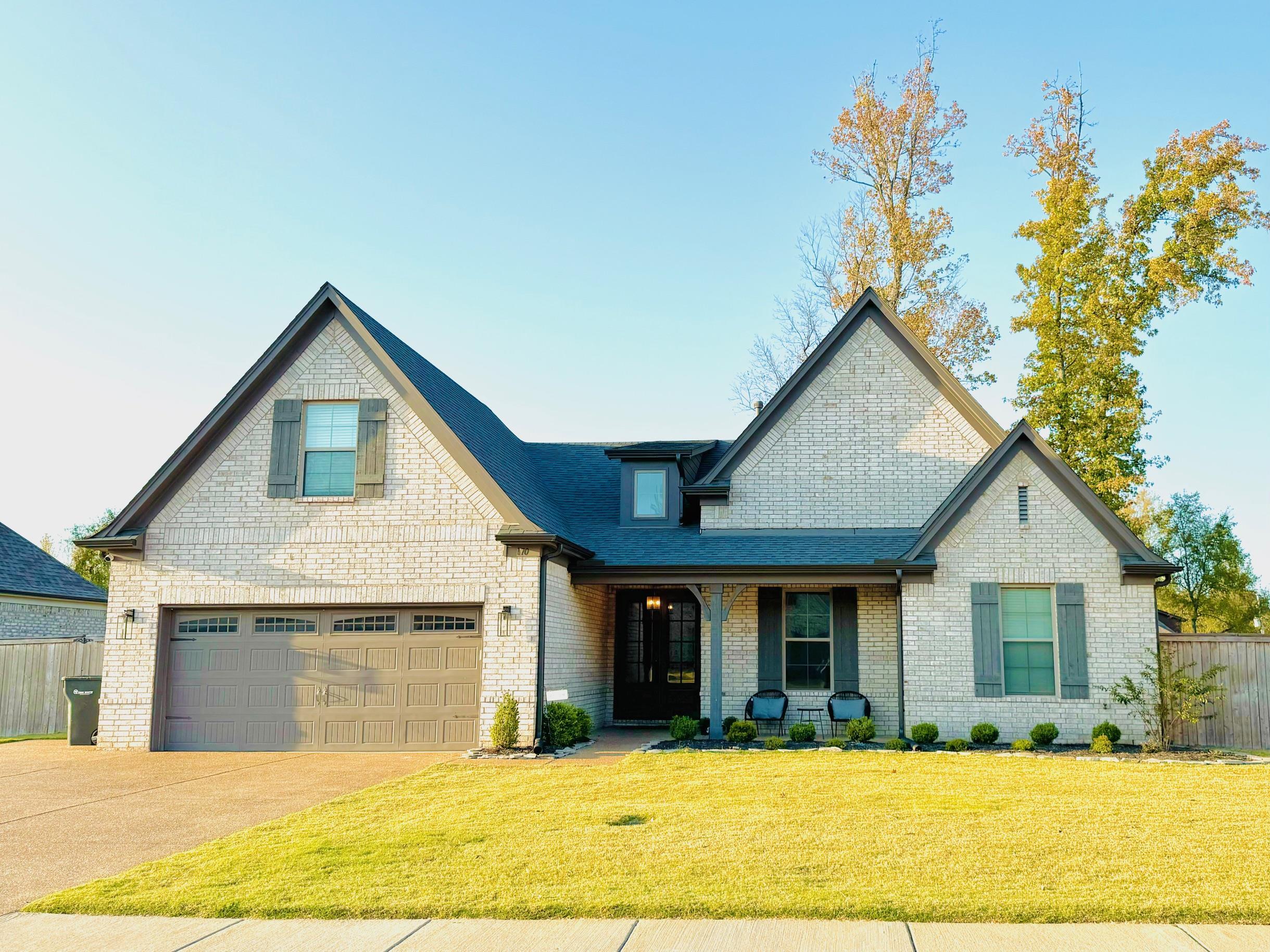 View of front of property featuring a front yard and a garage