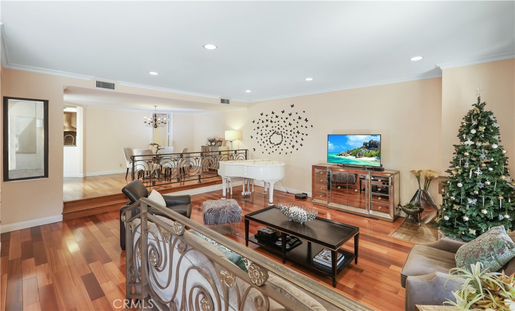 a living room with furniture a wooden floor and a potted plant