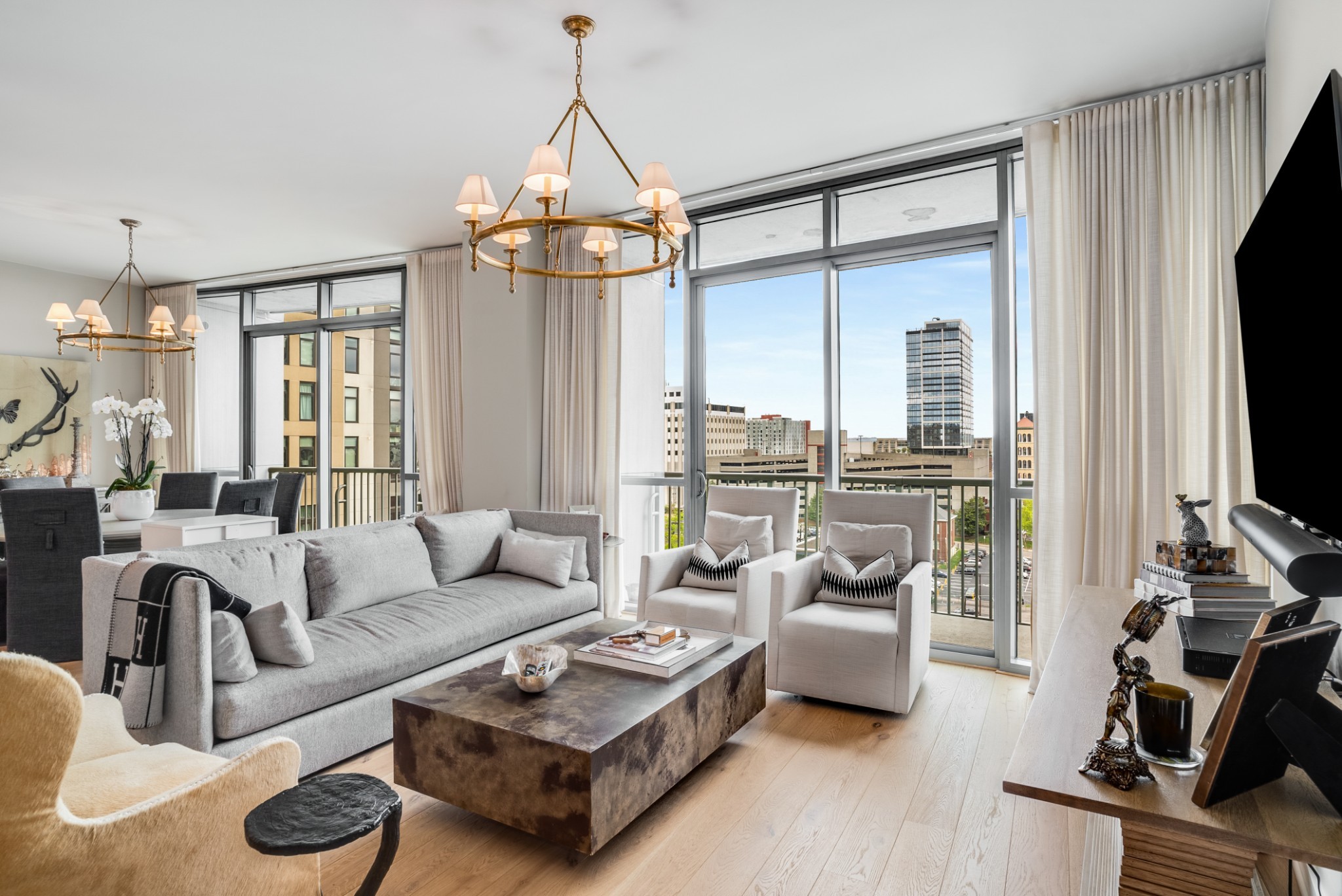 a living room with furniture a flat screen tv and a large window