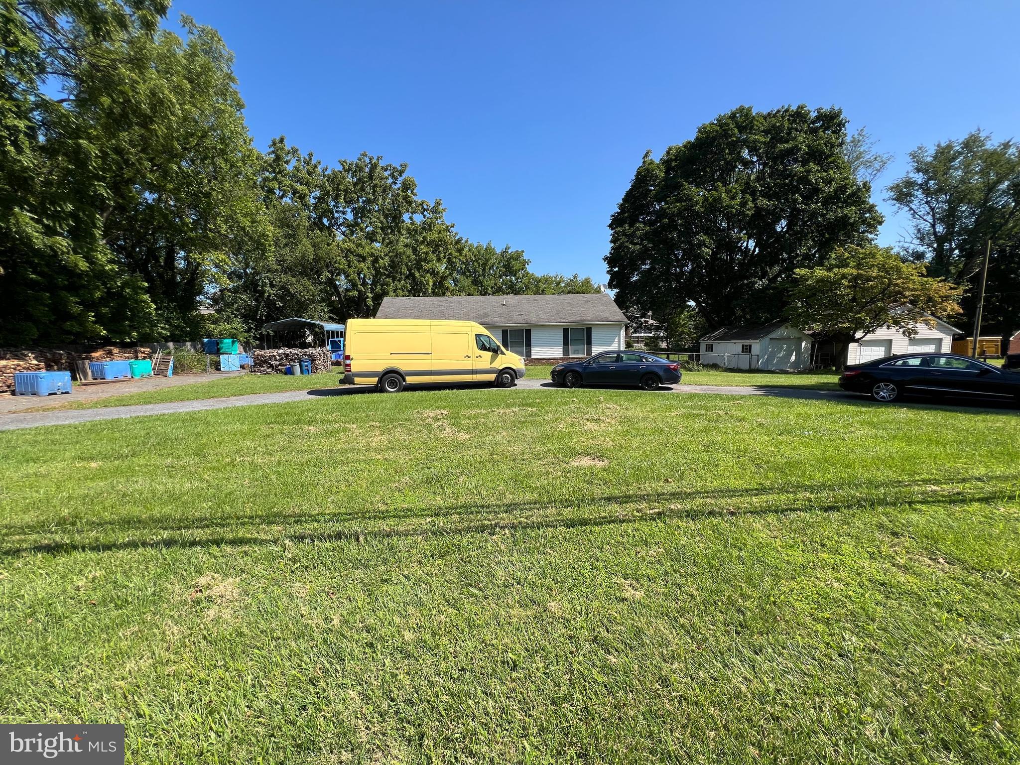 a view of a house with a big yard and large trees