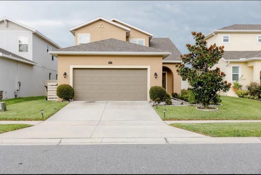 a front view of a house with a yard and garage