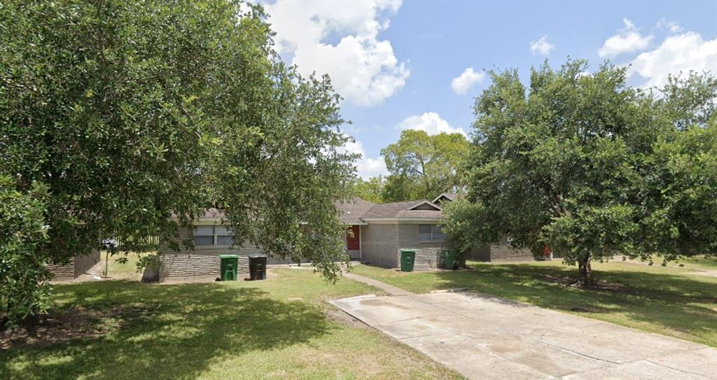 a front view of a house with a garden and trees