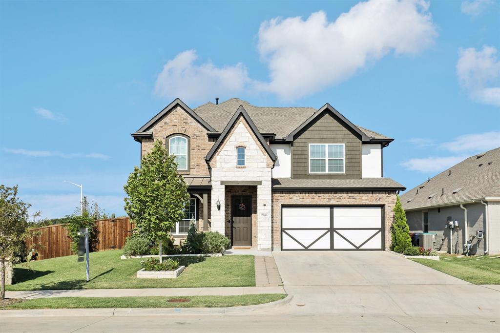 a front view of a house with a yard and garage