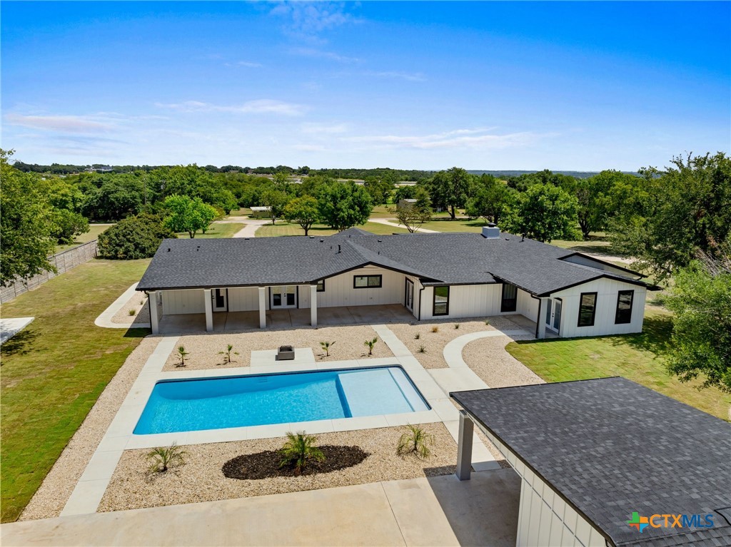 a aerial view of a house with swimming pool in front of it