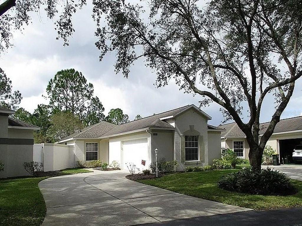 a front view of a house with a garden and trees