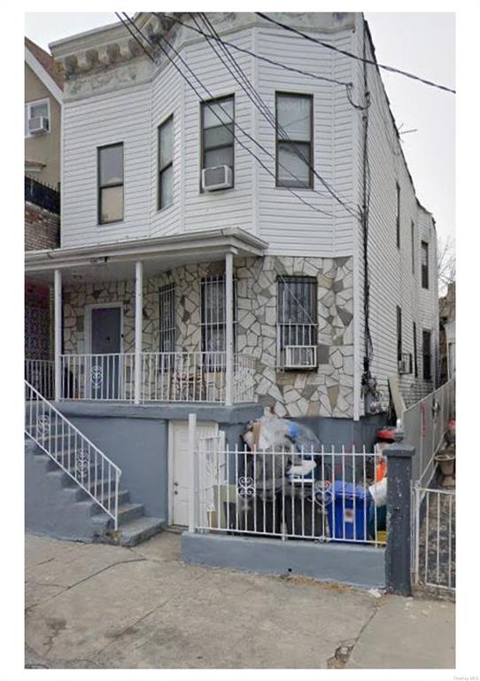 View of front of property featuring a wall unit AC and cooling unit