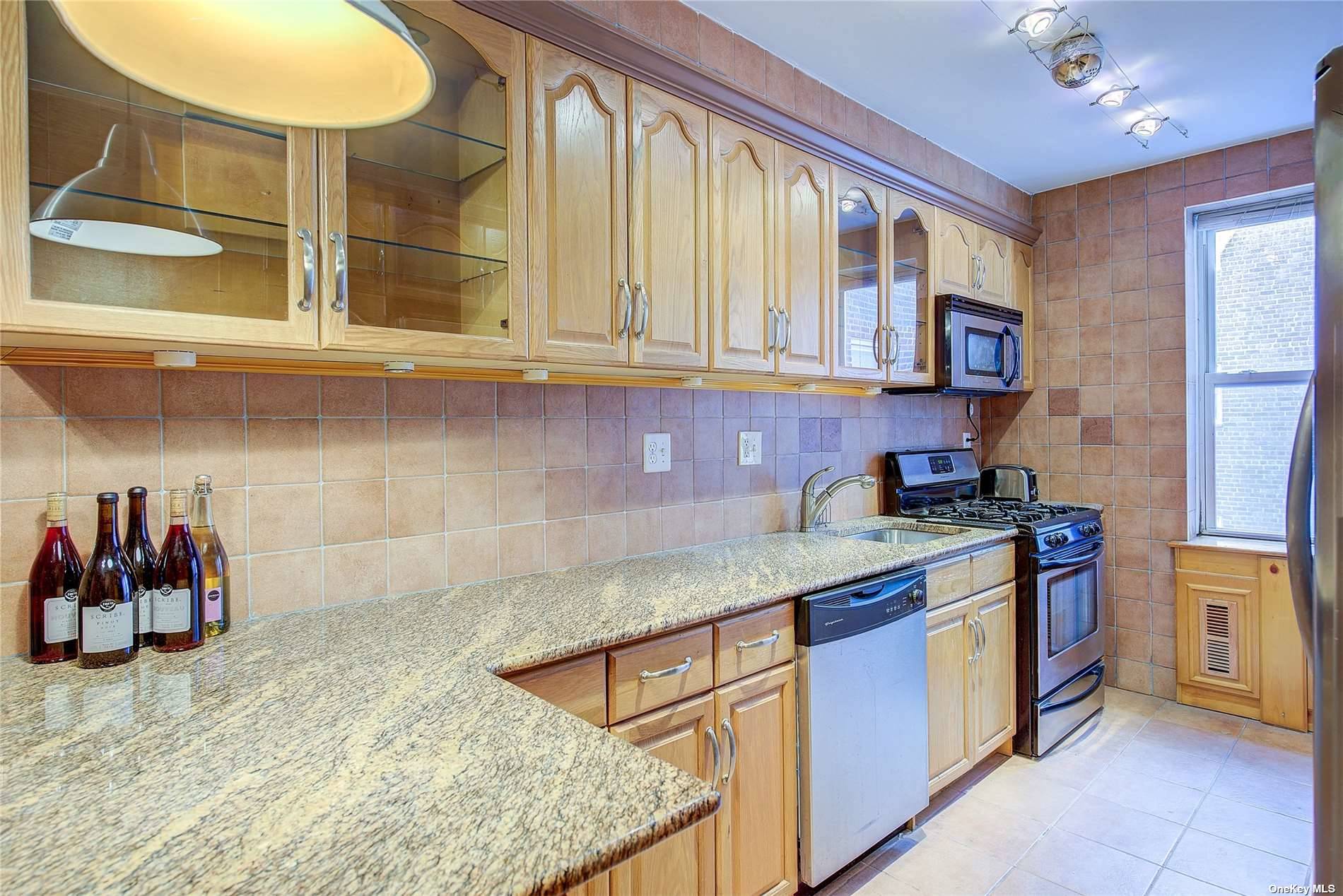 a kitchen with stainless steel appliances granite countertop a sink and cabinets