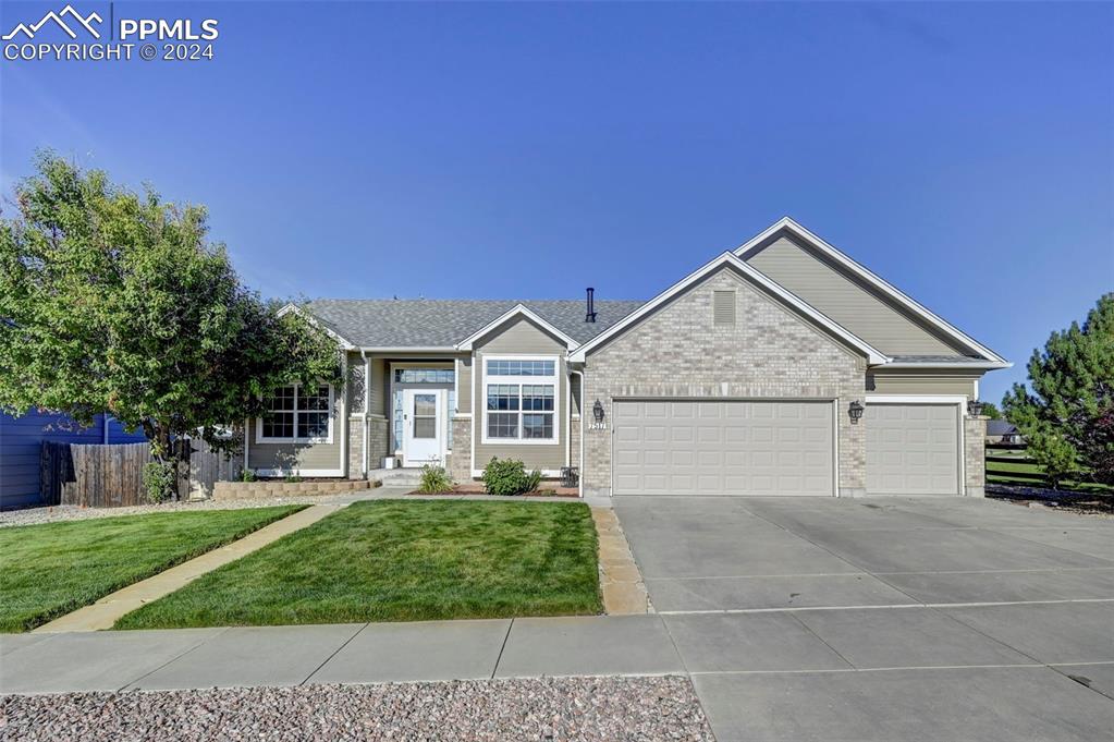 View of front of home featuring a garage and a front lawn