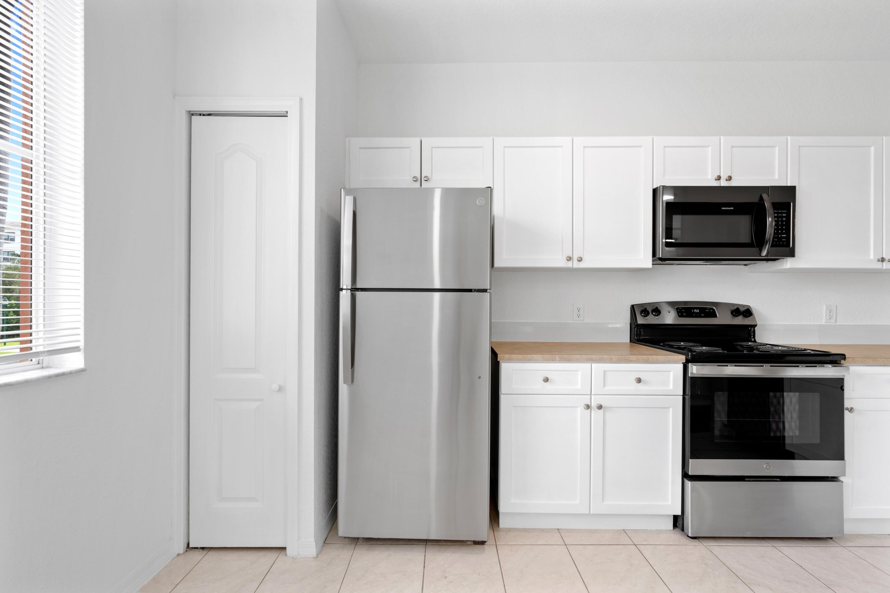 a kitchen with cabinets stainless steel appliances and a window