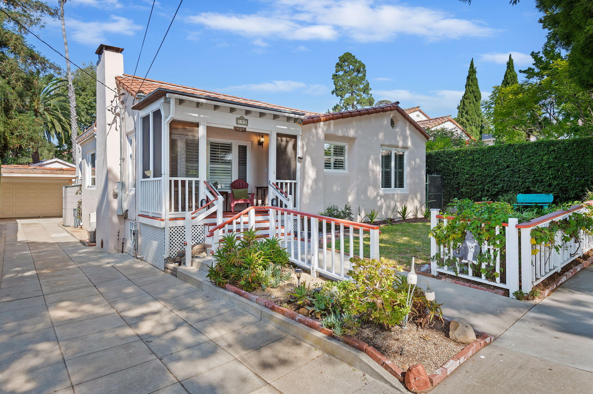 a view of a house with wooden fence next to a yard