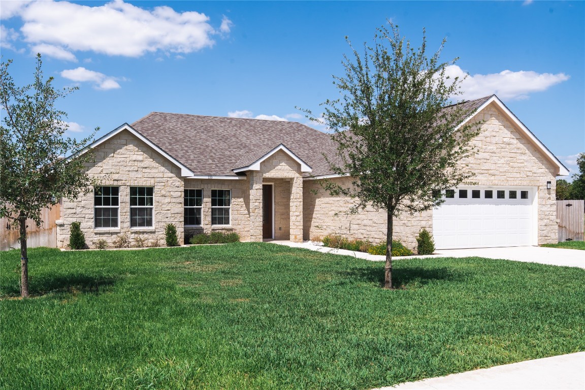 a front view of a house with a yard and trees