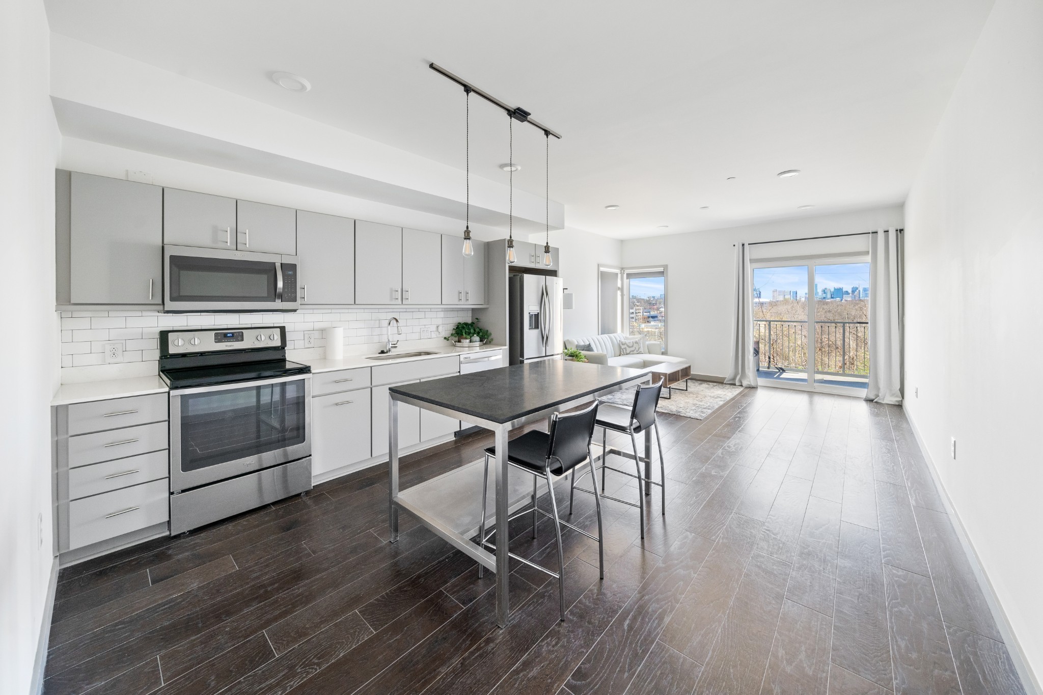 a kitchen with a table chairs stainless steel appliances and wooden floor