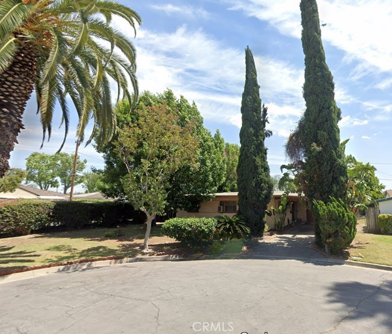 a front view of a house with a yard and potted plants