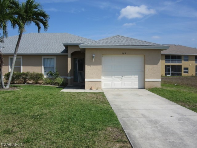 a front view of a house with a garden and yard