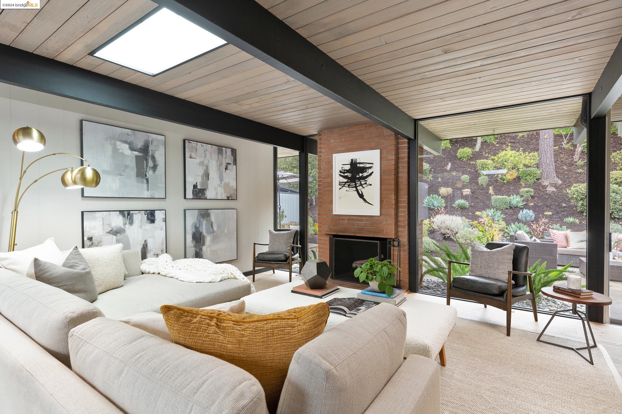 a living room with furniture fireplace and a large window