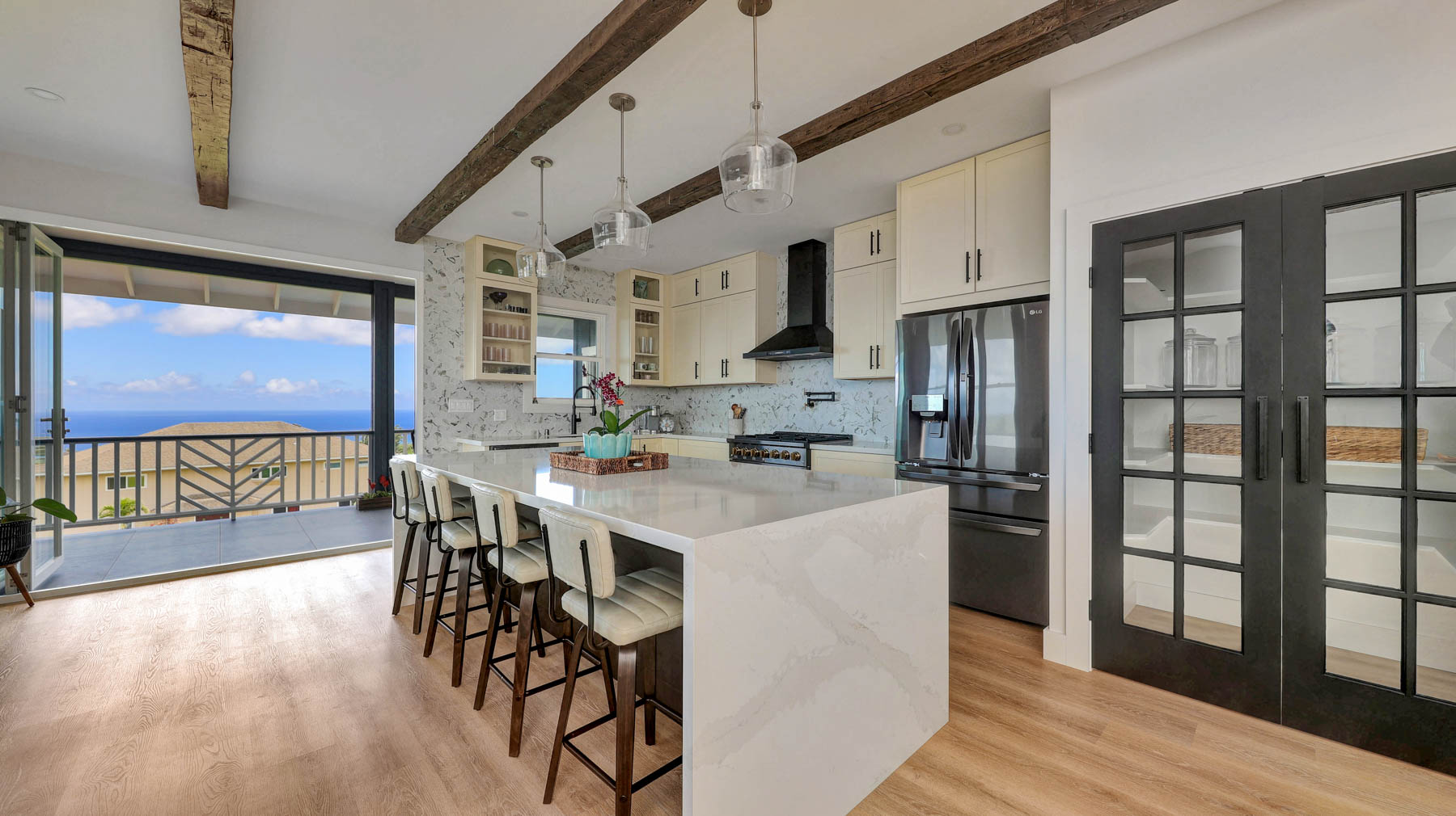 The "waterfall" quartz countertop on the kitchen island is huge. The French doors lead to the walk-in pantry.