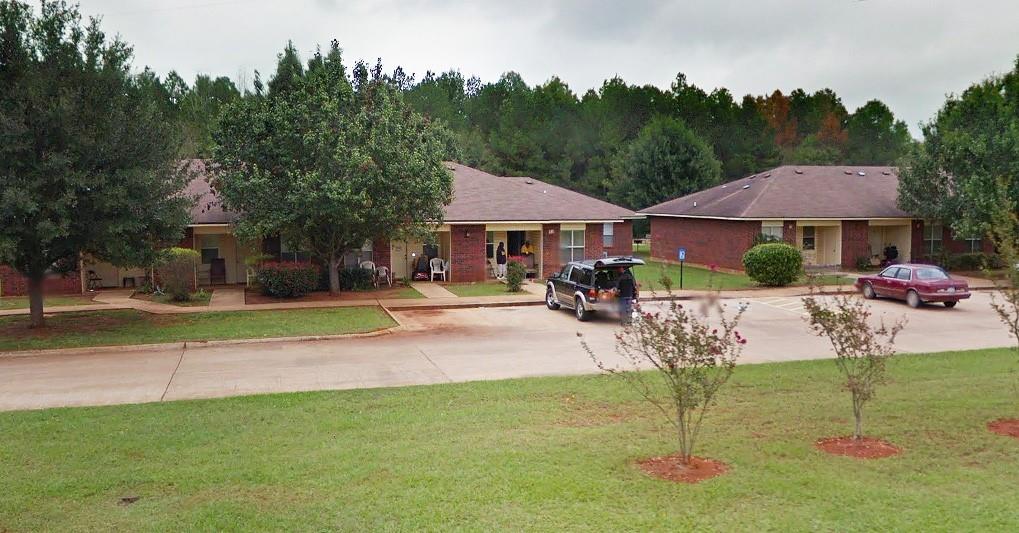 a swimming pool with barbeque oven outdoor seating and yard in the back